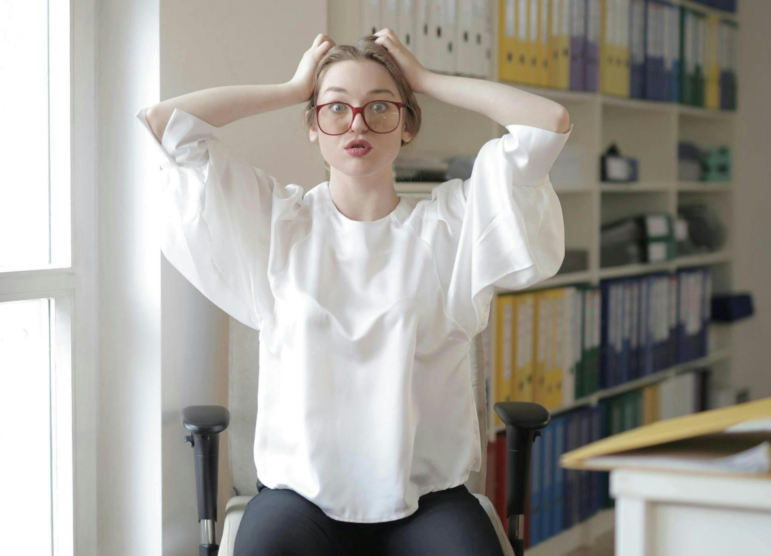 A woman looks alarmed and clutches the sides of her head