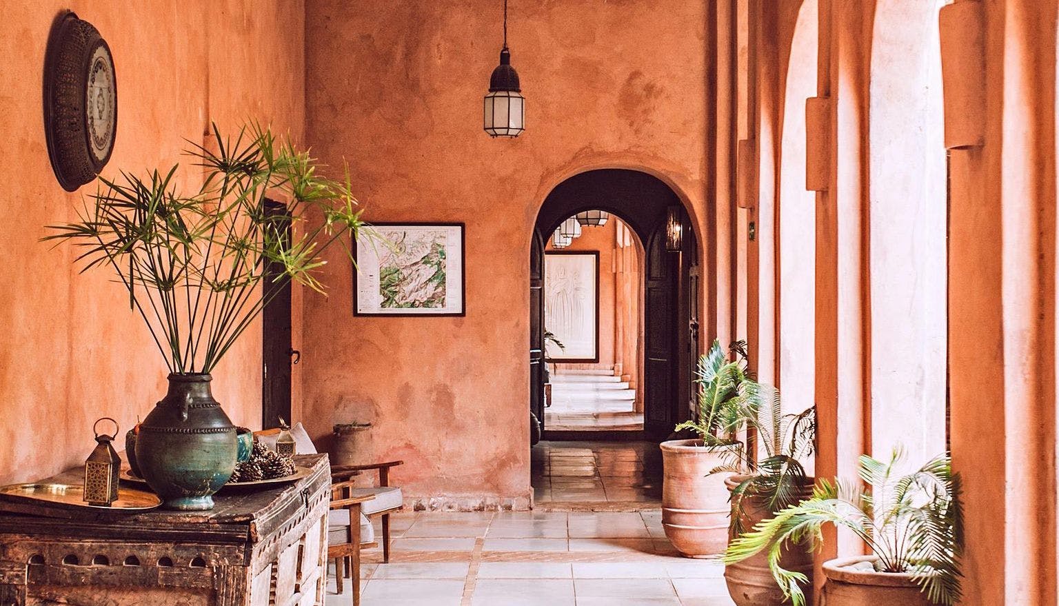 The interior of a property with archways, terracotta walls and plants