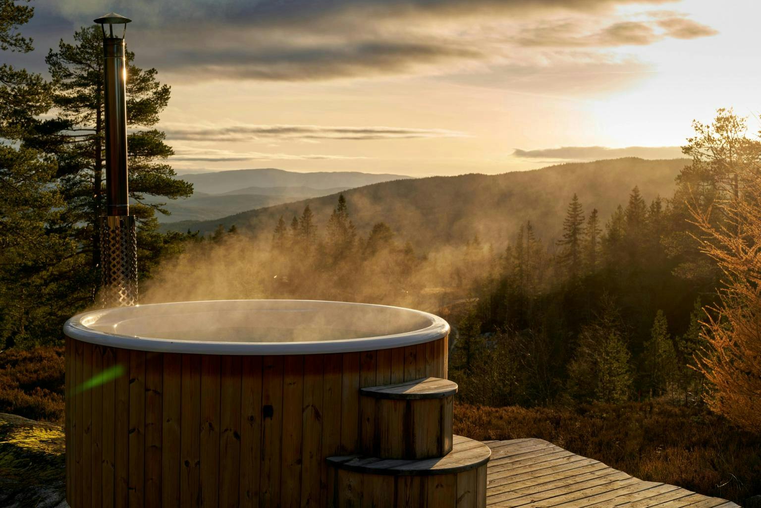 Image of a hot tub steaming at dusk overlooking a forest