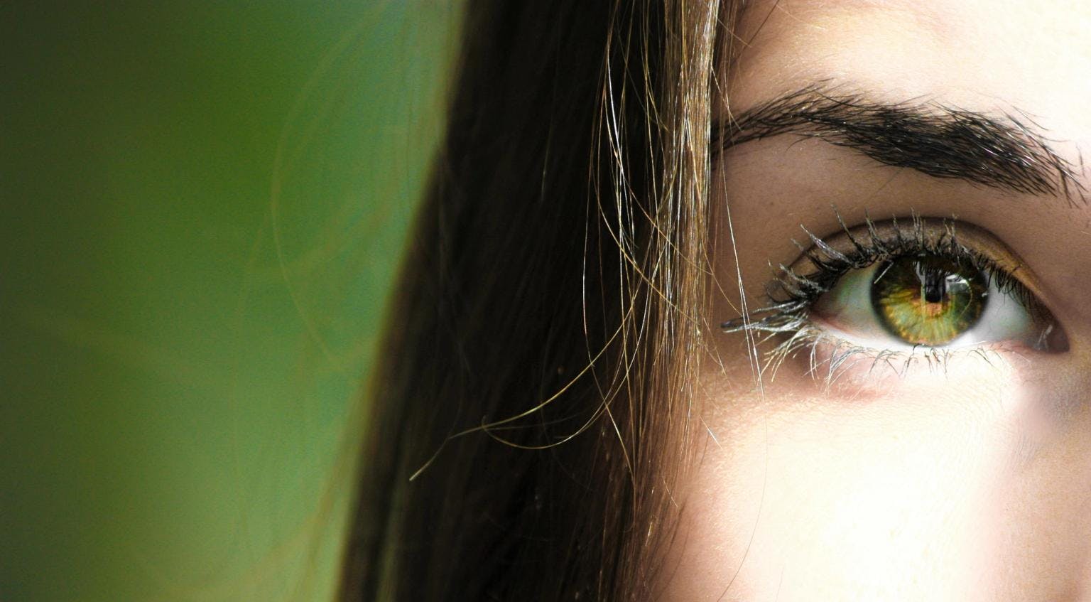 A close up shot of a woman's green eye